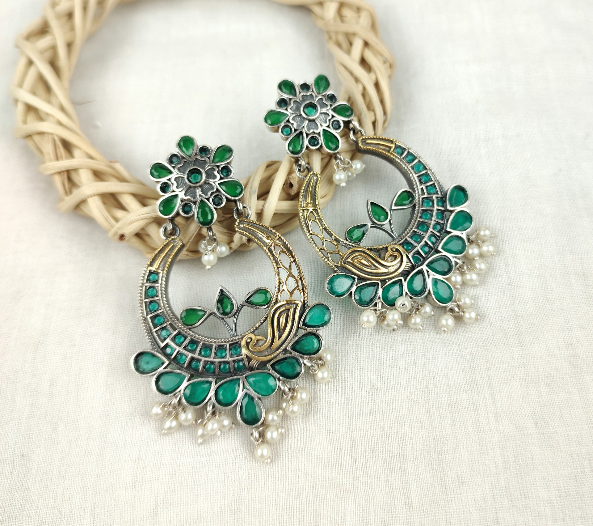 a close up of a pair of green and white earrings